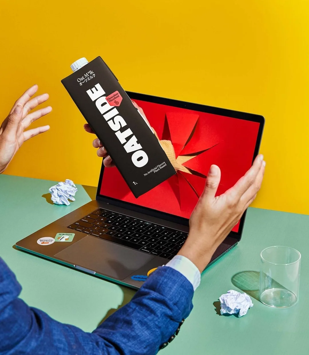 Oatside carton emerging from laptop screen